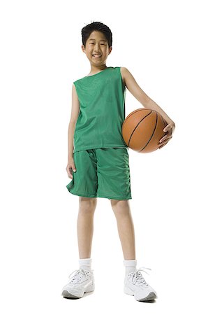 Portrait of a boy holding a basketball and smiling Stock Photo - Premium Royalty-Free, Code: 640-01356124