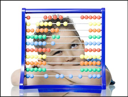 Close-up of a boy leaning in front of an abacus Stock Photo - Premium Royalty-Free, Code: 640-01356142