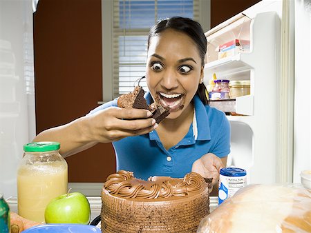 Woman devouring chocolate cake from refrigerator Stock Photo - Premium Royalty-Free, Code: 640-01356266