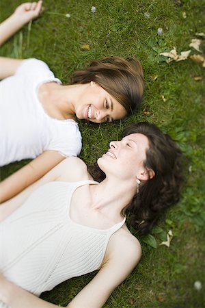 High angle view of two teenage girls lying on grass Stock Photo - Premium Royalty-Free, Code: 640-01356333
