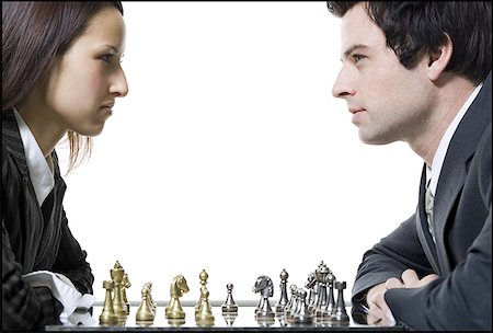 Close-up of a businessman and a businesswoman playing chess Stock Photo - Premium Royalty-Free, Code: 640-01356415