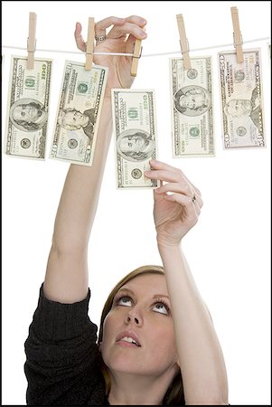 simsearch:640-01349807,k - Close-up of a young woman drying dollar bills on a clothesline Foto de stock - Sin royalties Premium, Código: 640-01356428