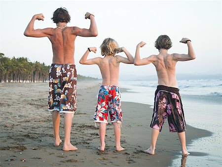 flexing muscles at beach - Three boys playing on beach Stock Photo - Premium Royalty-Free, Code: 640-01356432