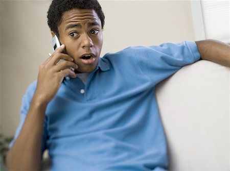 Teenage boy on a mobile phone with his mouth open Stock Photo - Premium Royalty-Free, Code: 640-01356454