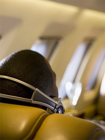 simsearch:640-02767934,k - Gros plan d'un homme à l'écoute de musique sur le casque dans un avion Photographie de stock - Premium Libres de Droits, Code: 640-01356552