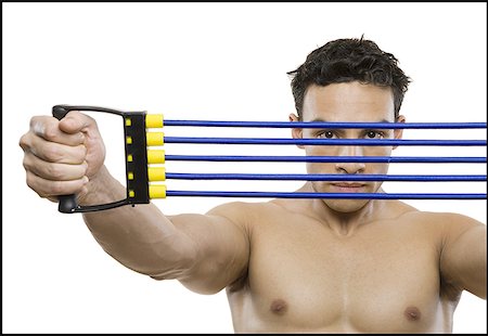 Portrait of a mid adult man stretching a resistance band Foto de stock - Sin royalties Premium, Código: 640-01356565