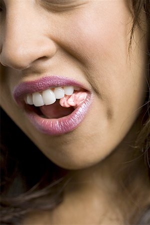 Close-up of a young woman chewing a bubble gum Stock Photo - Premium Royalty-Free, Code: 640-01356624