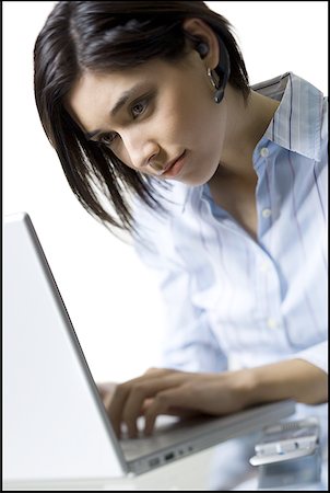 Close-up of a young woman working on a laptop Stock Photo - Premium Royalty-Free, Code: 640-01356711