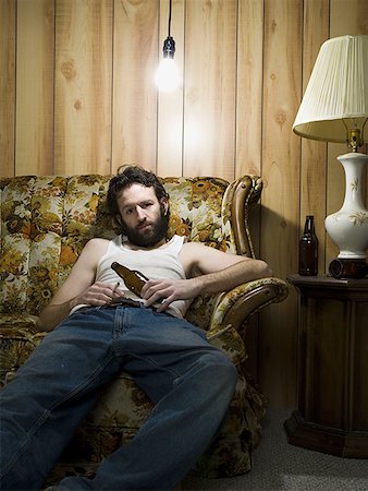 drunk at the sofa - Man sitting on sofa with cigarette and beer bottle Stock Photo - Premium Royalty-Free, Code: 640-01356777