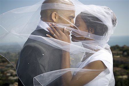 Profile of a newlywed couple kissing each other under a veil Foto de stock - Sin royalties Premium, Código: 640-01356883