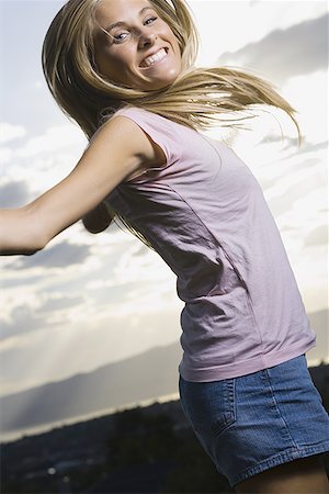 simsearch:640-01366443,k - Portrait of a young woman smiling and jumping Fotografie stock - Premium Royalty-Free, Codice: 640-01356894