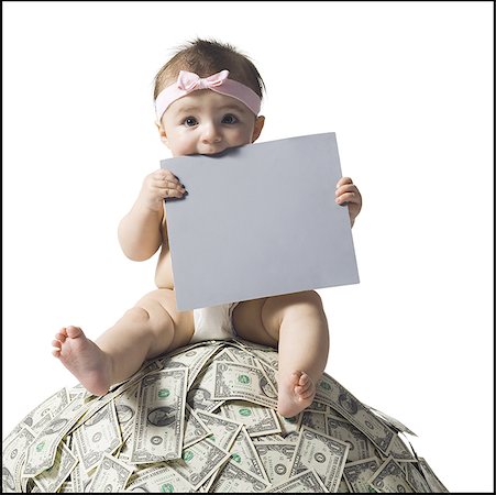 space money sign - Baby girl sitting on pile of US currency with blank sign Stock Photo - Premium Royalty-Free, Code: 640-01356909