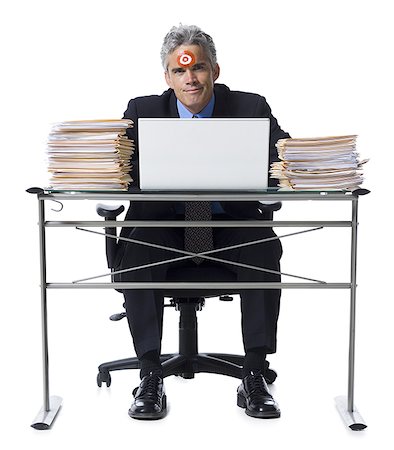 singled out - Man with bull's-eye on forehead working on laptop Stock Photo - Premium Royalty-Free, Code: 640-01356933