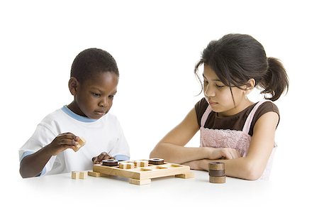 Close-up of a boy and a girl playing a board game Stock Photo - Premium Royalty-Free, Code: 640-01357037