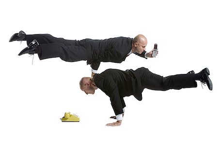 Profile of two male acrobats in business suits performing Fotografie stock - Premium Royalty-Free, Codice: 640-01357057