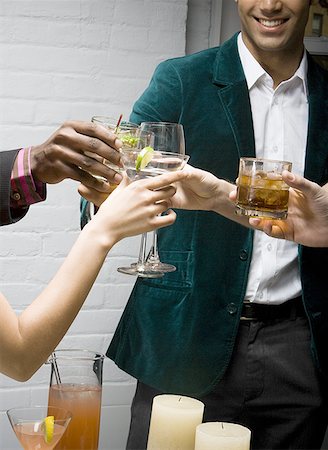 friends enjoying cocktail - Mid section view of a man toasting drinks with his friends at a party Stock Photo - Premium Royalty-Free, Code: 640-01357081