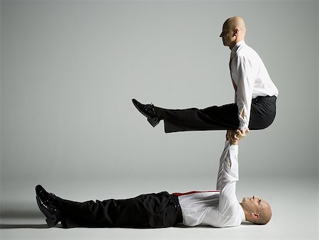reversing - Profile of two male acrobats in business suits performing Stock Photo - Premium Royalty-Free, Code: 640-01357119