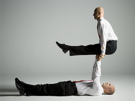 simsearch:640-02764552,k - Profile of two male acrobats in business suits performing Foto de stock - Royalty Free Premium, Número: 640-01357119