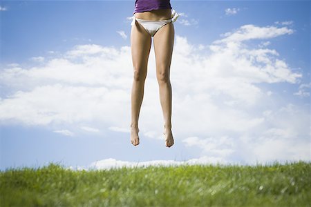 simsearch:640-01366443,k - Low section view of a young woman jumping in a garden Fotografie stock - Premium Royalty-Free, Codice: 640-01357161