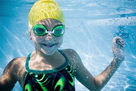 swimming goggles and cap - Girl swimming underwater in pool Stock Photo - Premium Royalty-Free, Code: 640-01357372