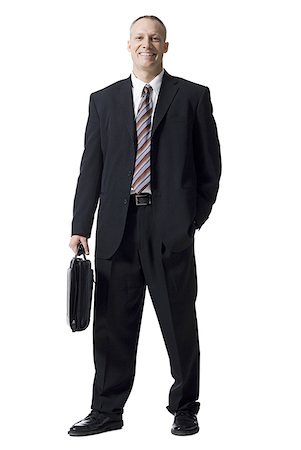 silhouette of businessman standing in office - Portrait of a businessman with briefcase smiling Stock Photo - Premium Royalty-Free, Code: 640-01357472