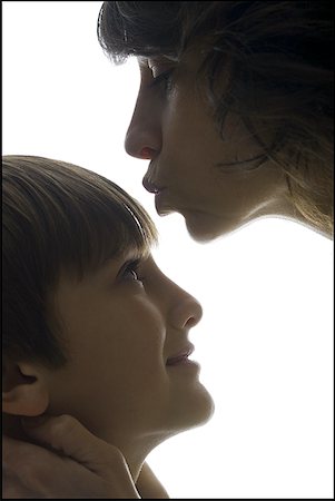 fashion boys 12 years - Close-up of a mid adult woman kissing her son's forehead Stock Photo - Premium Royalty-Free, Code: 640-01357704
