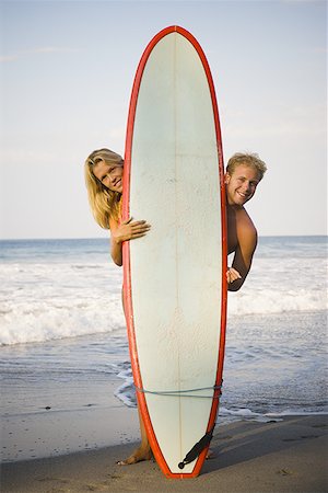 surfing extreme sport - Portrait of a mid adult woman and a young man holding a surfboard on the beach Stock Photo - Premium Royalty-Free, Code: 640-01357769