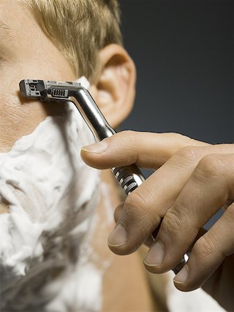 Close-up of a young man shaving Stock Photo - Premium Royalty-Free, Code: 640-01357779