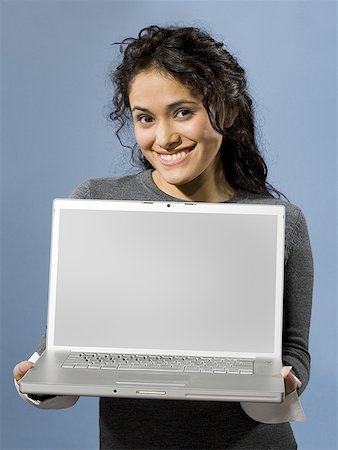 simsearch:640-01358649,k - Woman standing with blank laptop smiling Fotografie stock - Premium Royalty-Free, Codice: 640-01357788