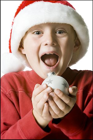 Portrait d'un garçon tenant un ornement de boule de Noël Photographie de stock - Premium Libres de Droits, Code: 640-01357790
