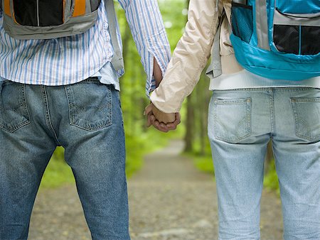 Mid section view of a young couple holding hands and standing Foto de stock - Sin royalties Premium, Código: 640-01357877