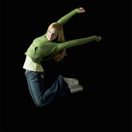 Girl leaping and smiling Stock Photo - Premium Royalty-Free, Code: 640-01357918