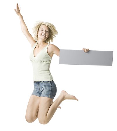 simsearch:640-01358649,k - Portrait of a young woman holding a blank sign and jumping Fotografie stock - Premium Royalty-Free, Codice: 640-01358043
