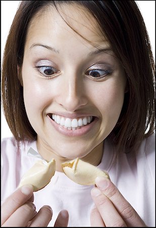Close-up of a young woman holding fortune cookie Foto de stock - Royalty Free Premium, Número: 640-01358150