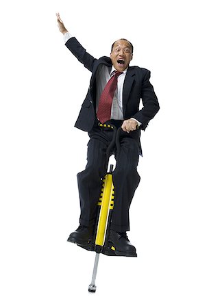 shout low angle - Portrait of a businessman on a pogo stick Stock Photo - Premium Royalty-Free, Code: 640-01358167