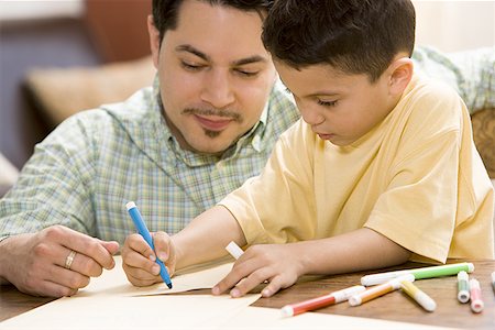 Young boy coloring and drawing with father supervising Stock Photo - Premium Royalty-Free, Code: 640-01358197