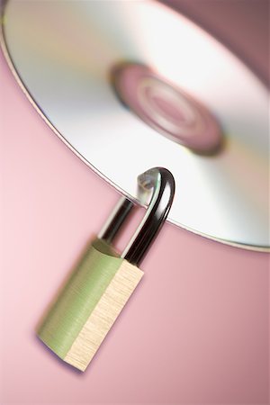 Close-up of a padlock hanging from a compact disc Foto de stock - Sin royalties Premium, Código: 640-01358204