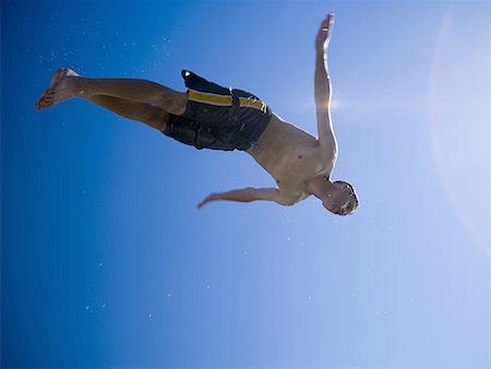Low angle view of a man diving Stock Photo - Premium Royalty-Free, Code: 640-01358205