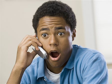 simsearch:640-01357796,k - Teenage boy on a mobile phone with his mouth open, looking surprised Foto de stock - Sin royalties Premium, Código: 640-01358252