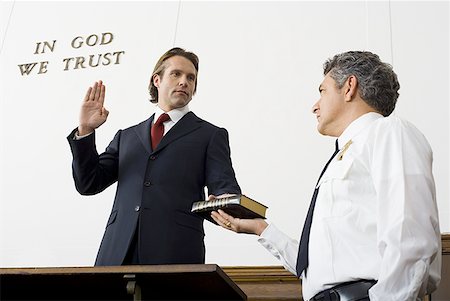 Low angle view of a witness swearing over the Bible Stock Photo - Premium Royalty-Free, Code: 640-01358291