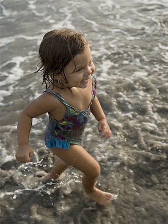 High angle view of a toddler girl running on the beach Stock Photo - Premium Royalty-Free, Code: 640-01358316