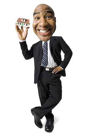 funny faces african american - Businessman holding a little toy house Stock Photo - Premium Royalty-Free, Code: 640-01358331