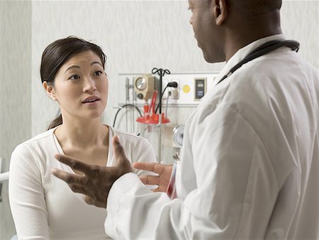 Profile of a male doctor talking to a young woman Stock Photo - Premium Royalty-Free, Code: 640-01358381