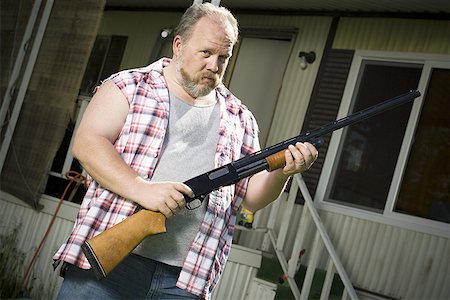 simsearch:640-01355830,k - Overweight man with a shotgun Stock Photo - Premium Royalty-Free, Code: 640-01358472