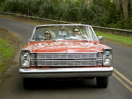 reflection on windshield - Young couple in a convertible car Stock Photo - Premium Royalty-Free, Code: 640-01358946