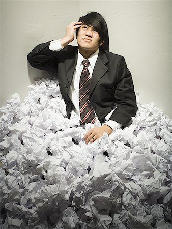 Businessman buried in mountain of crumpled papers Stock Photo - Premium Royalty-Free, Code: 640-01359004