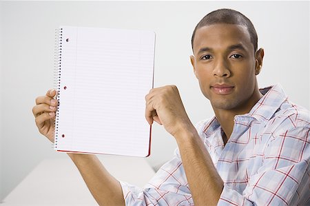 simsearch:640-02768435,k - African American male student holding blank workbook Fotografie stock - Premium Royalty-Free, Codice: 640-01359016