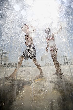 Two children playing at a sprayground Stock Photo - Premium Royalty-Free, Code: 640-01359097