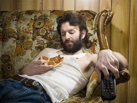 simsearch:640-01351574,k - Man on sofa with pizza and remote Fotografie stock - Premium Royalty-Free, Codice: 640-01359154