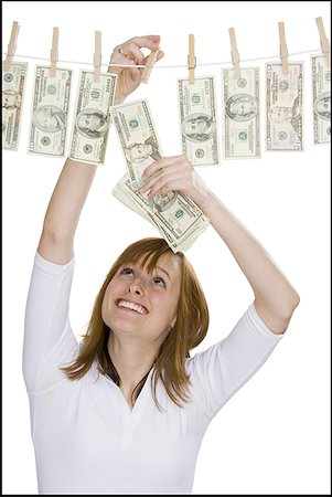 simsearch:640-01349807,k - Close-up of a young woman drying dollar bills on a clothesline Foto de stock - Sin royalties Premium, Código: 640-01359210